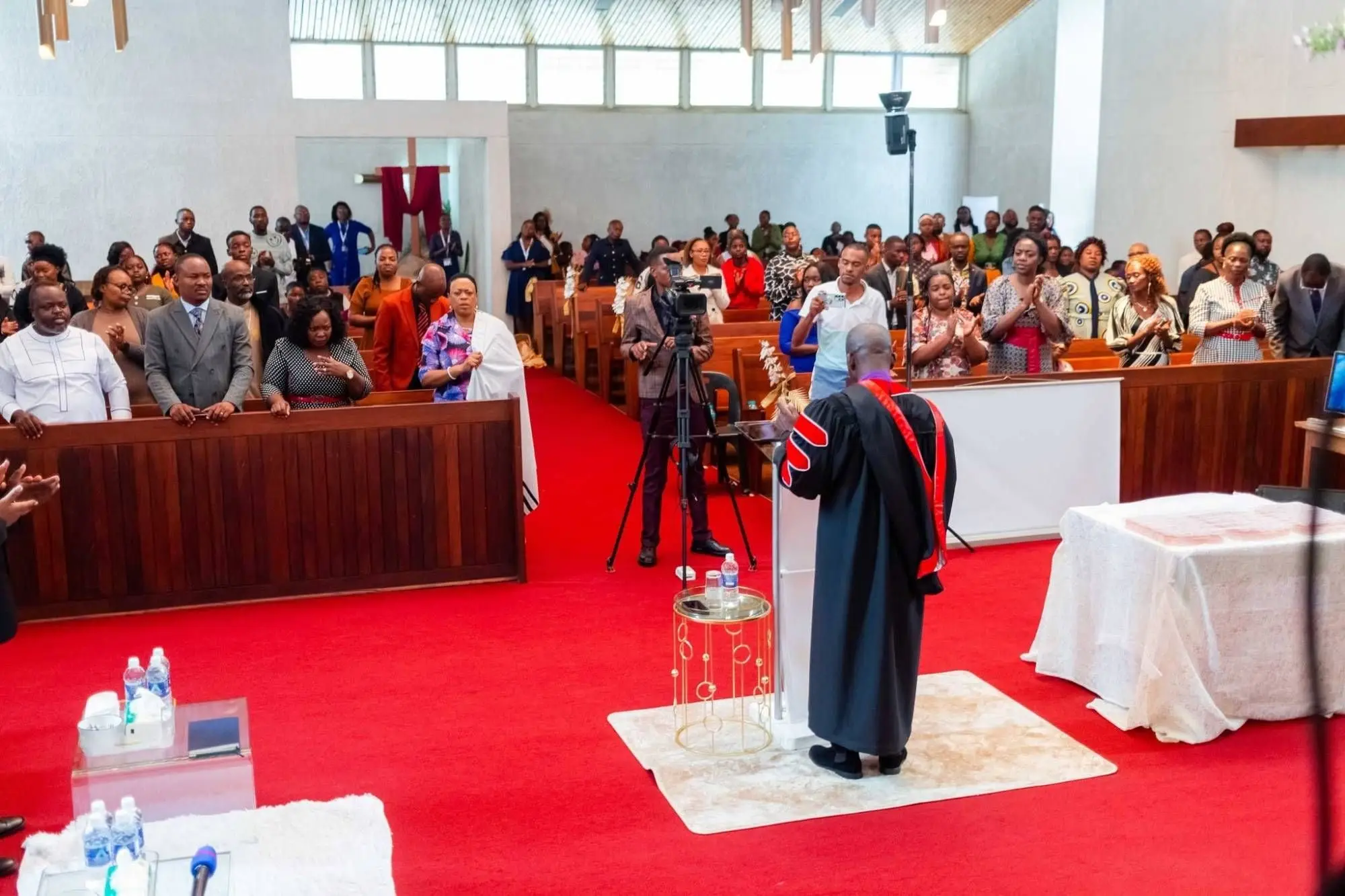 The congregation standing during a Sunday service, seen from the front of the church